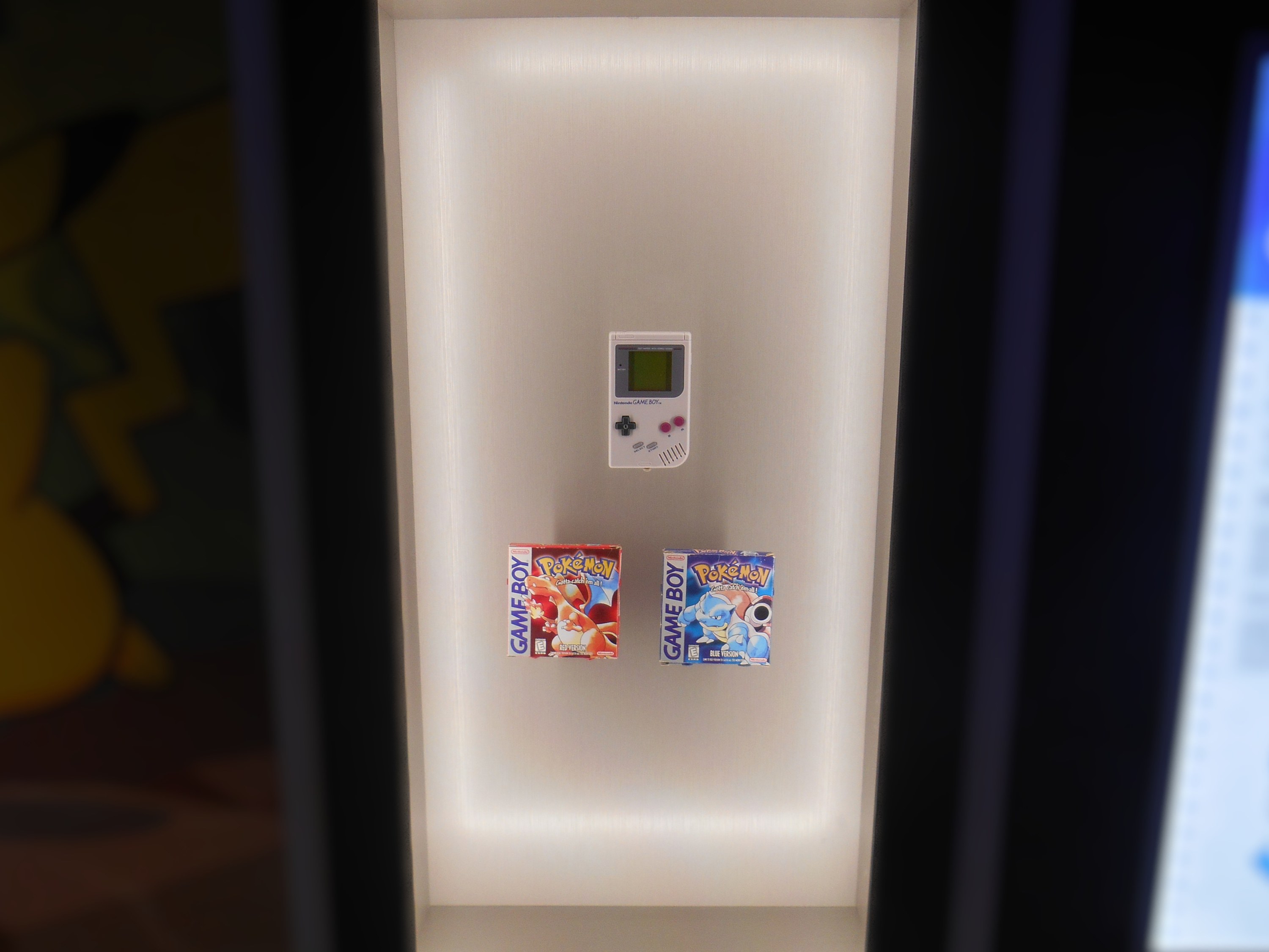 A Game Boy and the box art for Pokémon Red Version and Pokémon Blue Version on display at the entrance to the Pokémon Fossil Exhibit | Taken Sept 30, 2026, by Fabrizio E. Paco